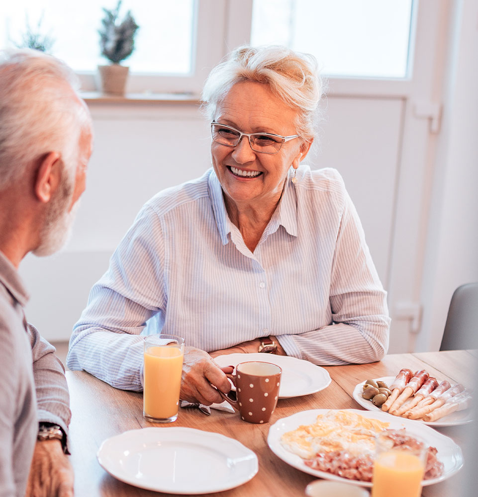 senior woman benefitting from dentures and eating a meal